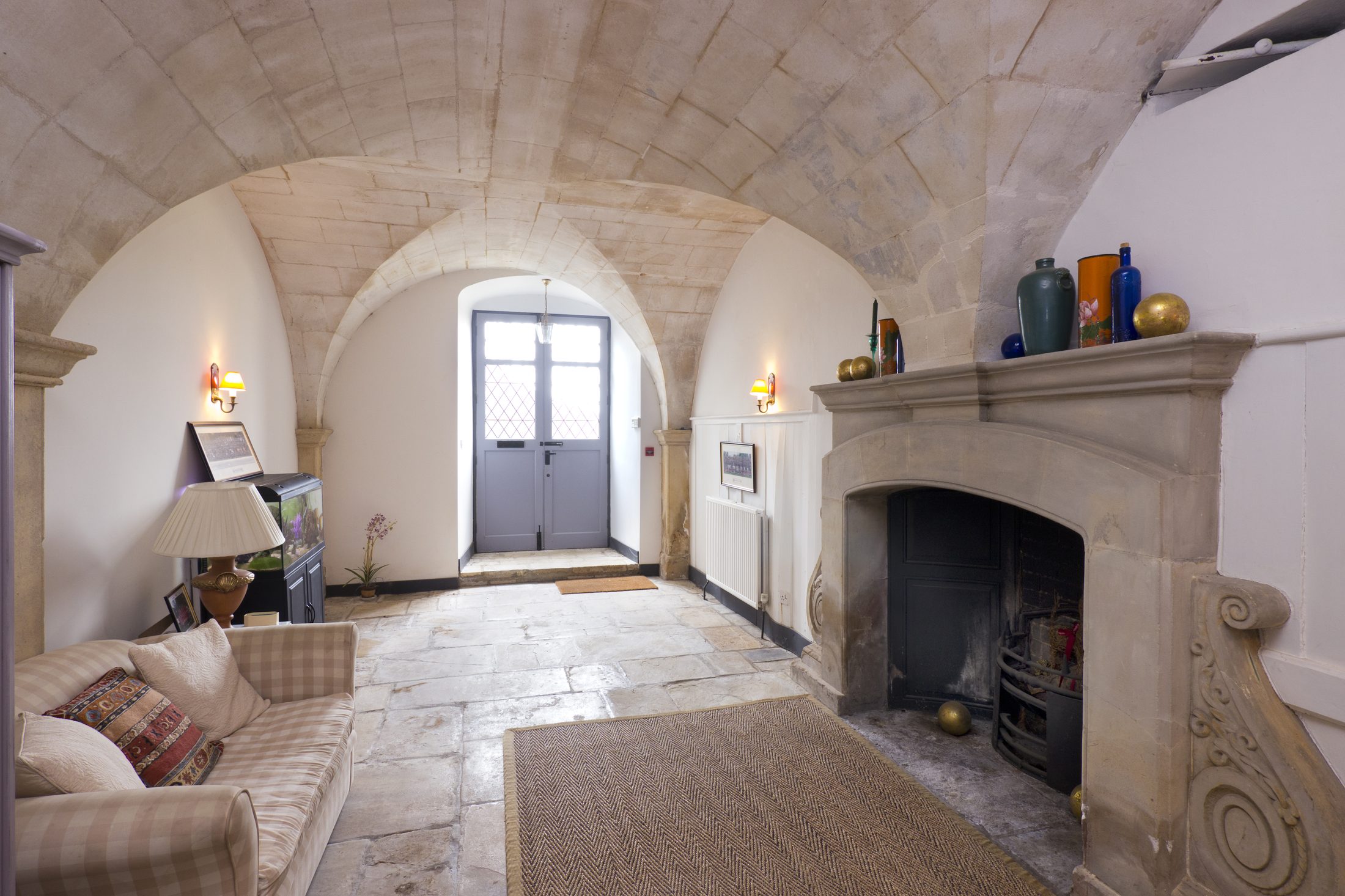 The stone-vaulted entrance hall, with a flagged floor and a large stone fireplace said to be salvaged from the Duke of Buckingham's original house
