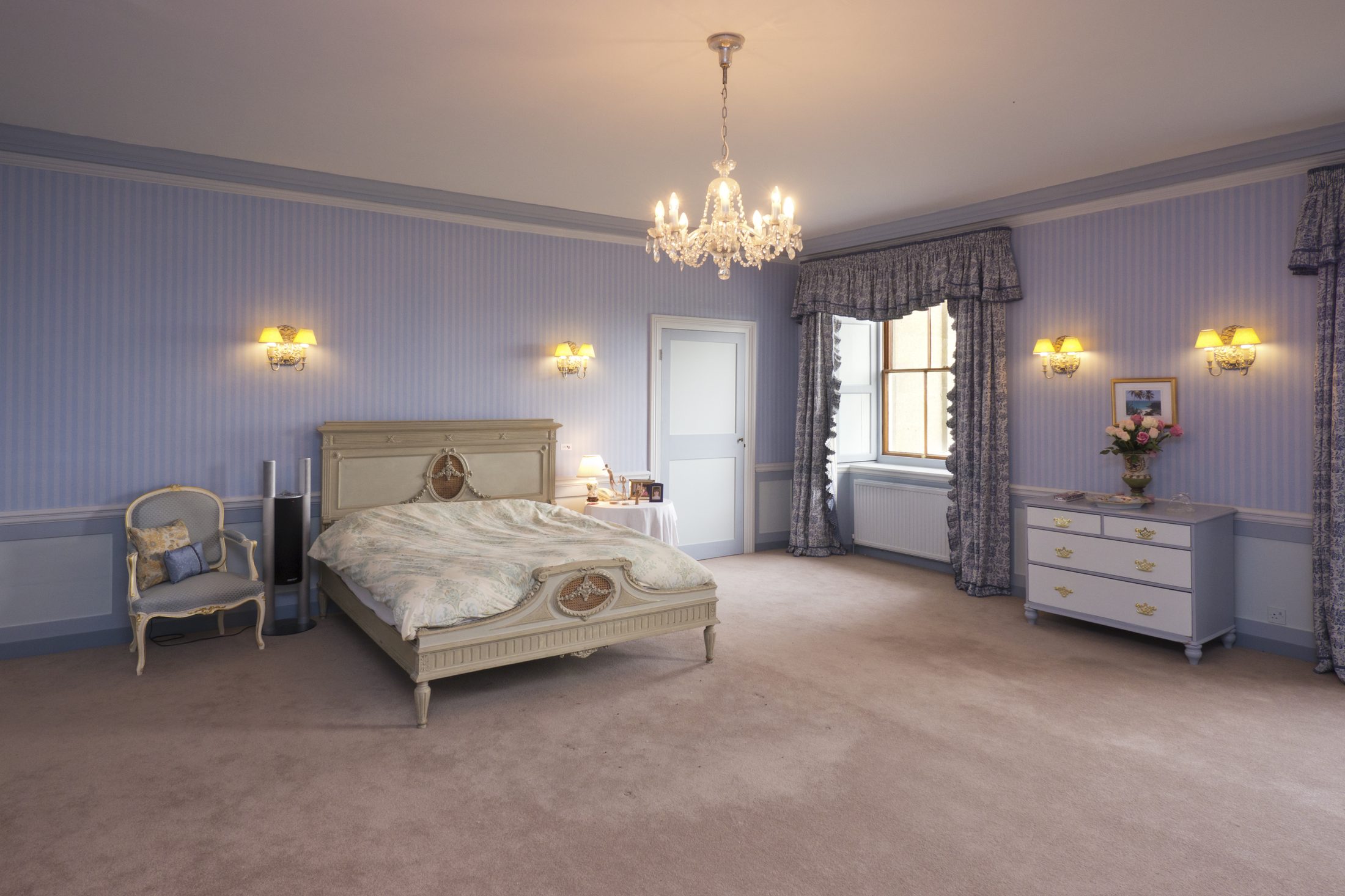 Bedroom 2, with lilac walls and a chandelier